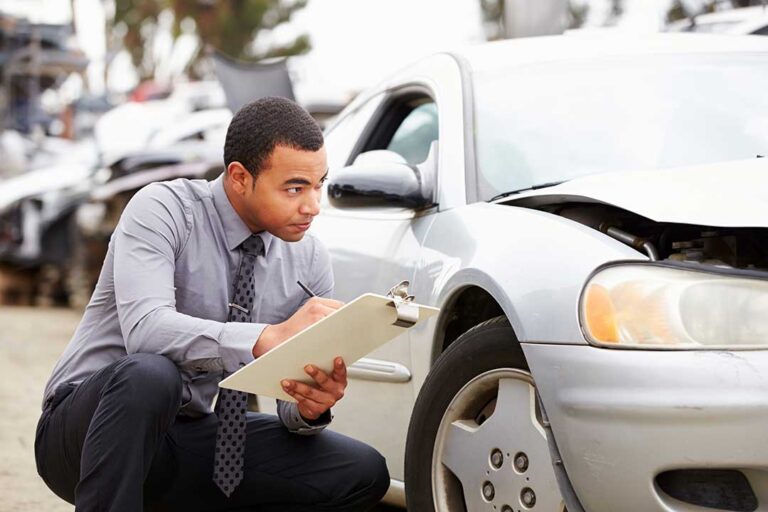 Driver reviews insurance documents beside a new car with registration papers and an insurance card.